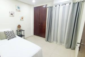 a bedroom with a bed and a wooden door at Apartamento nuevo, Asunción. in Asunción