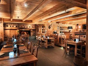 a restaurant with wooden tables and chairs and a fireplace at Fer à Cheval in Megève