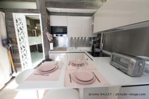 a kitchen with a table with plates and a microwave at NID DOUILLET DE FLAINE in Flaine +4 photos