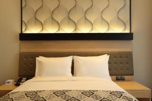 Postel nebo postele na pokoji v ubytování AI Hotel Jakarta Thamrin