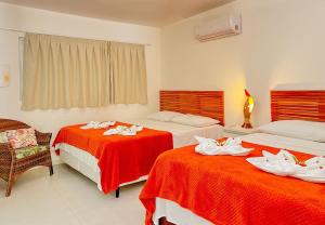 une chambre d'hôtel avec deux lits et une chaise dans l'établissement Solar Água Pipa- Summer Pipa, à Pipa