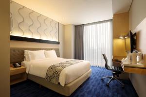 Postel nebo postele na pokoji v ubytování AI Hotel Jakarta Thamrin