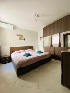 a bedroom with a bed with two blue towels on it at Mela Apartment 1 in St Paul's Bay +19 photos