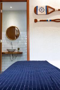 a bedroom with a blue bed and a sink at Casa Lanai - Perto de Restaurantes e da Capela Milagres - Internet 300 Mbs in São Miguel dos Milagres