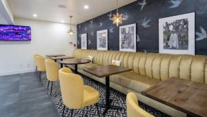 a restaurant with wooden tables and yellow chairs at The Catrina Hotel in San Mateo