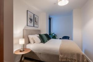 - une chambre avec un lit et une table avec une lampe dans l'établissement Kula Manchester, à Manchester