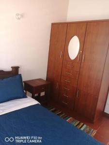 a bedroom with a bed and a wooden dresser at Casa Donde Gomez in Villa de Leyva