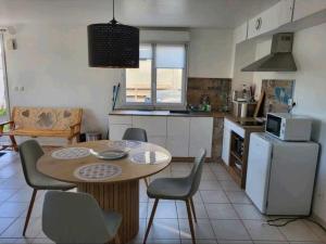 a kitchen with a table and chairs and a refrigerator at Appartement camon in Camon +1 photo