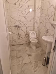 y baño con aseo y lavamanos. en Apartments Picioski en Peštani