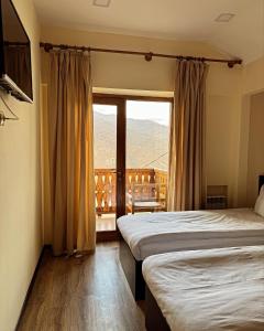 a hotel room with two beds and a window at Verin Tun in Dilijan