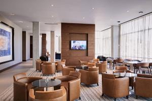 a restaurant with tables and chairs and a flat screen tv at AC Hotel by Marriott Phoenix Tempe/Downtown in Tempe