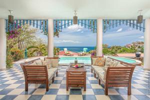 a living room with a couch and chairs and a pool at Villa Sol Y Sombra in Schœlcher