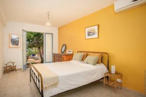 a bedroom with a bed and a yellow wall at Villa Sol Y Sombra in Schœlcher