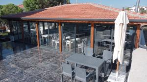 een paviljoen met stoelen, een tafel en een parasol bij Akarca Butik Otel in Tepecik