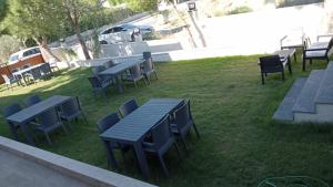 een groep picknicktafels en stoelen op een gazon bij Akarca Butik Otel in Tepecik