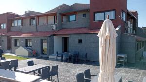 een gesloten parasol op een terras voor een gebouw bij Akarca Butik Otel in Tepecik