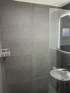 a bathroom with a glass shower with a sink at Dormís Acá in Esquel