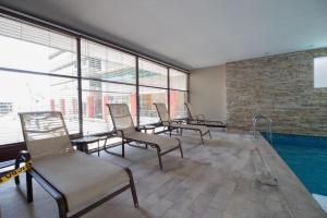 uma sala de piscina com cadeiras e uma piscina em Torres del sol 2 em Guayaquil