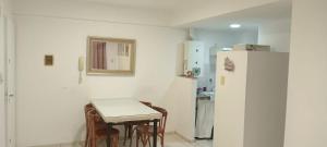 a kitchen with a small table and a refrigerator at Departamento Ricchieri 743 in Rosario +8 photos