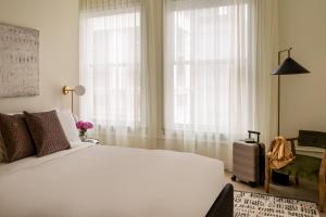Un dormitorio con una gran cama blanca y una ventana en Sonder The Craftsman, en Los Ángeles