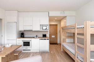 a kitchen and a living room with a bunk bed at Viola apartments in Rovaniemi