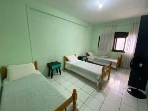 a bedroom with two beds and a window at Pousada355 in Passo Fundo