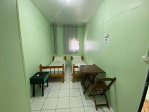a small room with chairs and a table and a table at Pousada355 in Passo Fundo