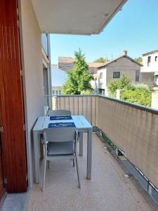 einen Tisch und einen Stuhl auf dem Balkon in der Unterkunft Le Moth Marseillan in Marseillan