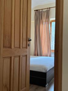 1 dormitorio con 1 cama y puerta con ventana en Verin Tun, en Dilijan