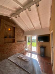 a bedroom with a bed and a brick wall at Lazlo in Sierra de los Padres