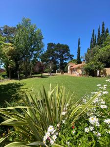 un parque verde con flores y un campo de hierba en Lazlo en Sierra de los Padres