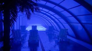 a blue tunnel with chairs and a palm tree at Wczasowa 8 Apartments in Sarbinowo