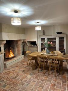 a large kitchen with a table and a fireplace at Gîte du fournil « Chez Nicole » in Ully-Saint-Georges
