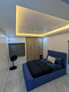 1 dormitorio con 1 cama azul en una habitación en Easyinn Shortlet Apartment, en Port Harcourt
