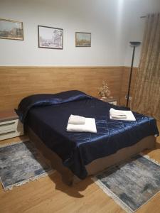 a bedroom with a bed with two towels on it at Downtown Authentic Apartment Tirana Myslym Shyri in Tirana