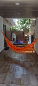 an orange hammock in the middle of a room at Casa de praia Rocha Alves em Porto de Galinhas in Porto De Galinhas