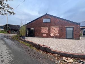 a brick house with a gravel driveway in front of it at Marmalade Barn Guest Suite with wet room in Rugeley