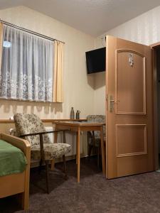 a room with a desk and a table and a door at Pension Grasse & GenießerImbiss 