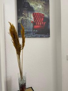 une photo d'une chaise rouge et d'un vase sur une table dans l'établissement Rheinview Sunset in Urbar, à Urbar