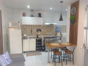 a kitchen with a table and a stove and a refrigerator at Casa de praia Rocha Alves em Porto de Galinhas in Porto De Galinhas