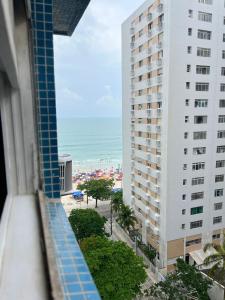 uma vista para a praia a partir da varanda de um edifício em CARIBONI no Guarujá