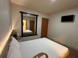 巴西利亚Pousada do Atleta的带床和大镜子的卧室