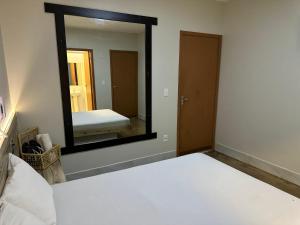 um quarto com uma cama e um espelho grande em Pousada do Atleta em Brasília