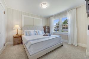マートルビーチにある200ft to beach! North Myrtle Beach first level duplex home, pet friendly!の白いベッドルーム(ベッド1台、窓付)