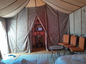 Adrouineにあるmerzouga berber tentsのテント(椅子、テーブル付)が備わる客室です。