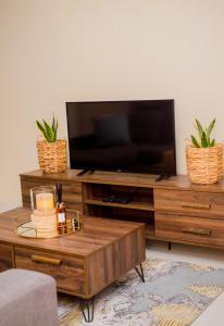 una sala de estar con TV en un centro de entretenimiento de madera en Davi Bliss, en Oshakati