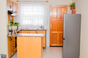 a kitchen with a refrigerator and a wooden door at Davi Bliss in Oshakati