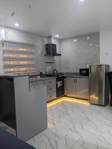 a kitchen with stainless steel appliances and a marble floor at Easyinn Shortlet Apartment in Port Harcourt