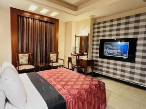 a hotel room with a bed and a flat screen tv at Jiati Business Motel in Zhubei