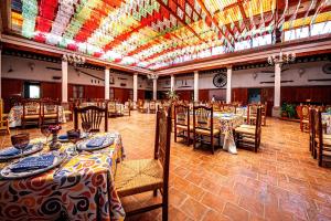 einen Bankettsaal mit Tischen und Stühlen und einer farbenfrohen Decke in der Unterkunft Hotel Hacienda Cantalagua Golf in Contepec